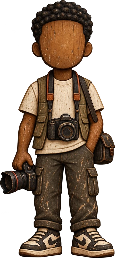 A carved wooden figure in a utility vest holding one camera and wearing another, a shoulder bag at his side